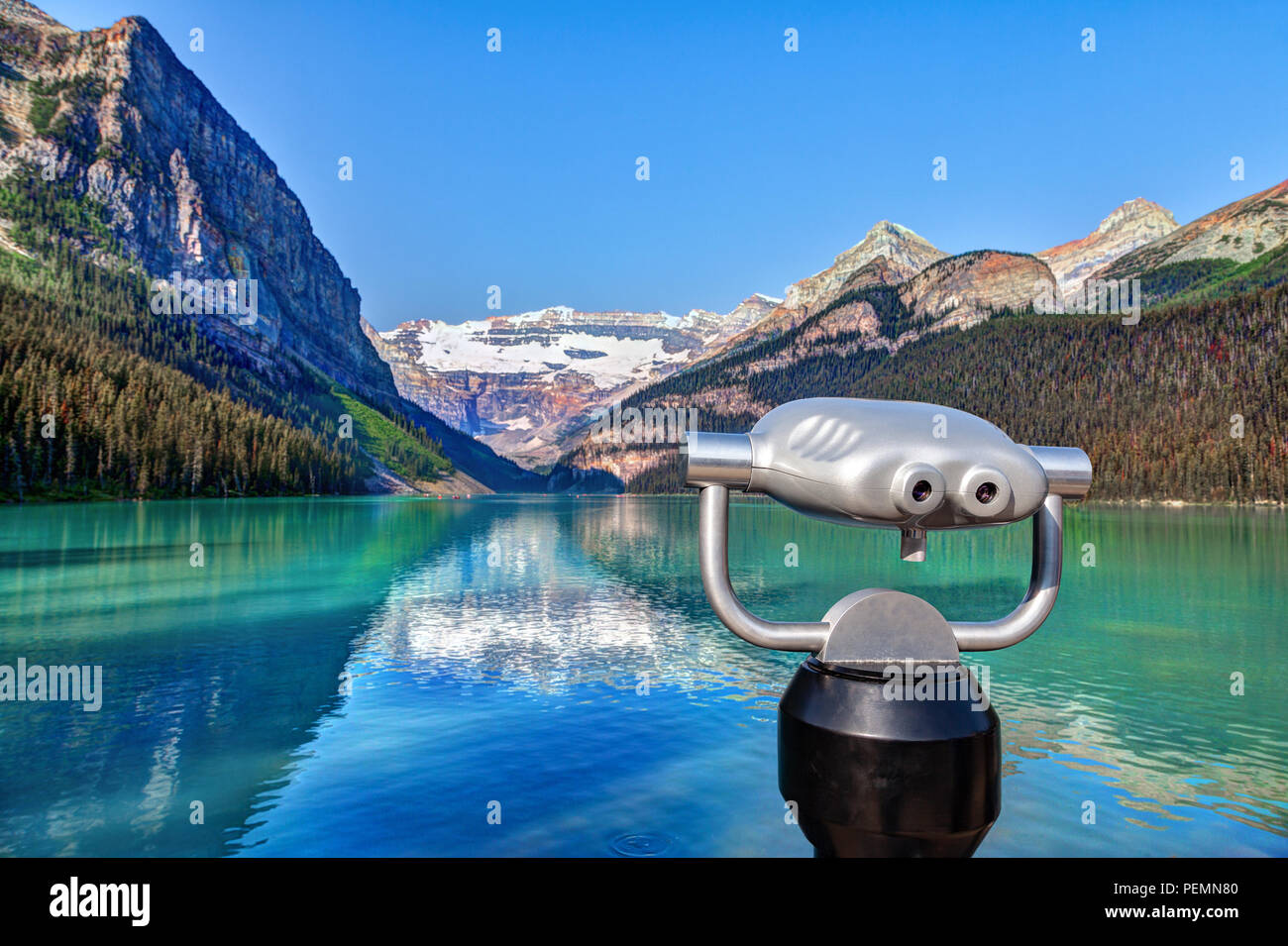 Focus on a tower viewer or binoculars at Lake Louise in Banff National Park  with its glacier-fed turquoise lakes and Mount Victoria Glacier in the bac  Stock Photo