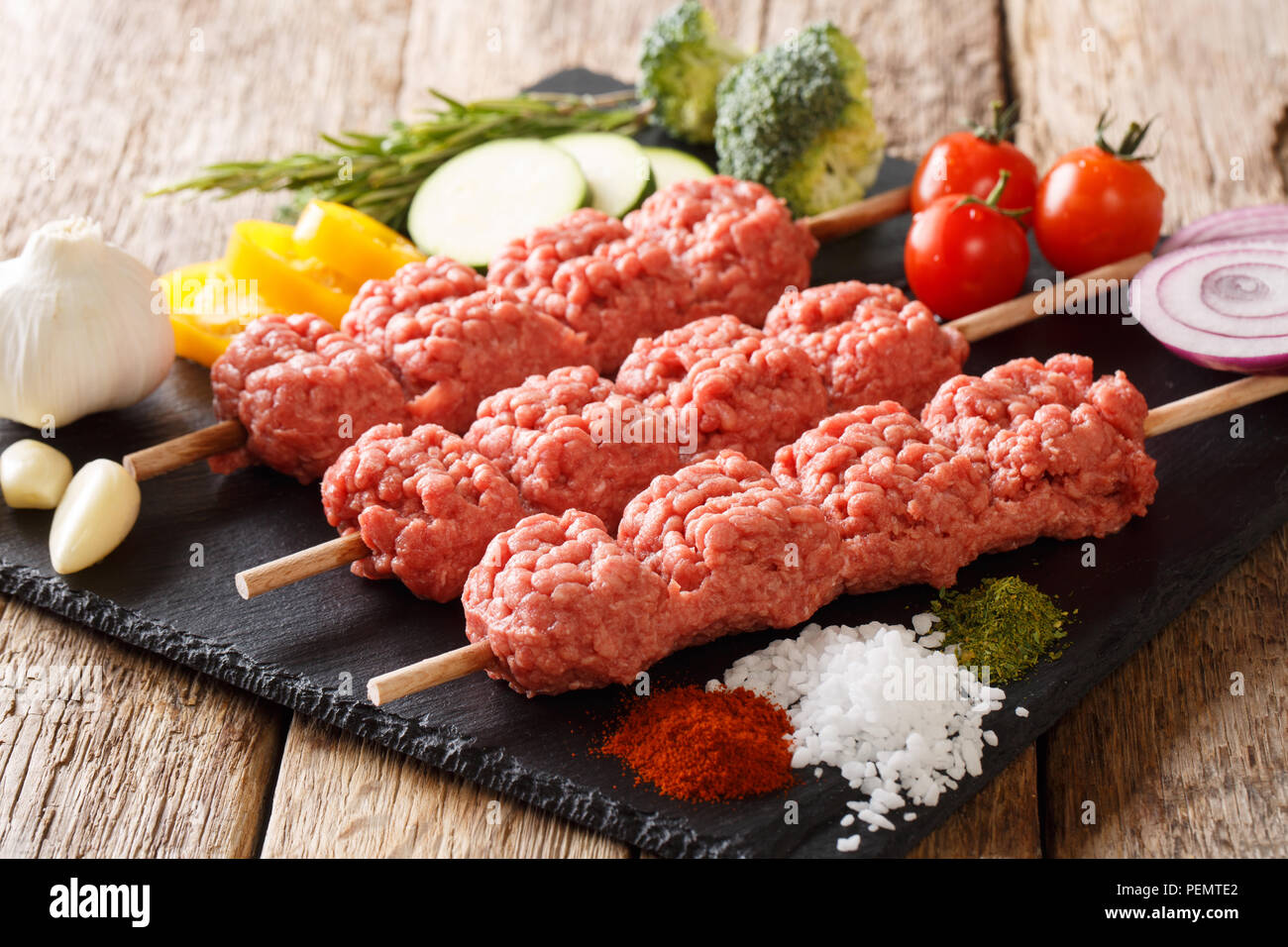 Homemade kebabs from raw minced meat on skewers with spices, herbs and