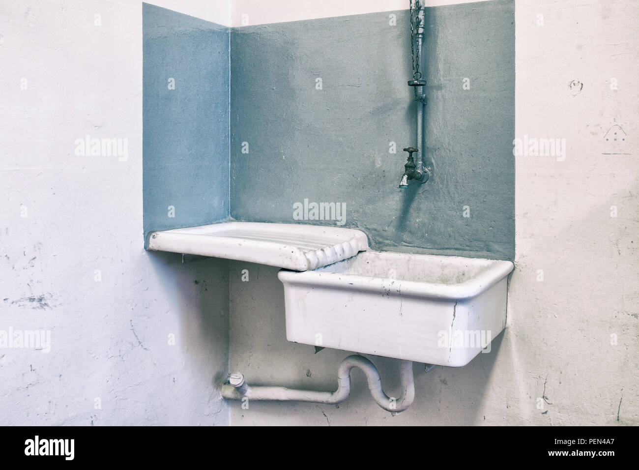 Old vintage sink with copper faucet with a gray background. Stock Photo