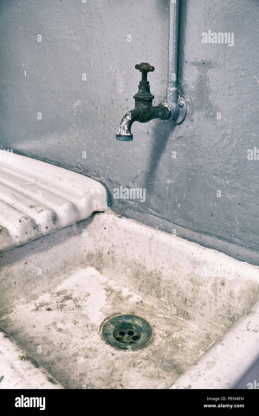 Old vintage sink with copper faucet and a gray background Stock Photo