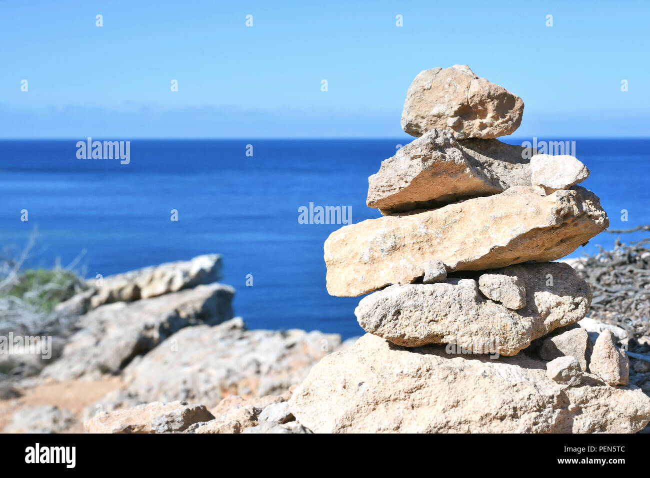 Stacked stones or zen-like stone stack on a high coast with view to the sea. Stock Photo