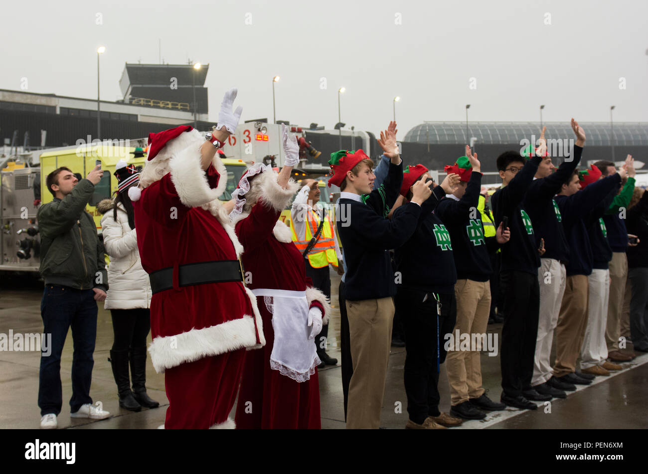 Santa and Mrs. Claus along with volunteer students from Notre Dame College Prep wave to the plane while standing on the tarmac as the Snowball Express taxis out to the runway on Dec. 12. The program is sponsored by American Airlines, coordinating flights from 84 cities via nearly 60 chartered and commercial flights. The Snowball Express is a nonprofit organization established in 2006, providing an all-expenses-paid trip to families across the United States with a mission of bringing hope and new memories to the children of military heroes who have died while on active duty since Sep. 11, 2001. Stock Photo