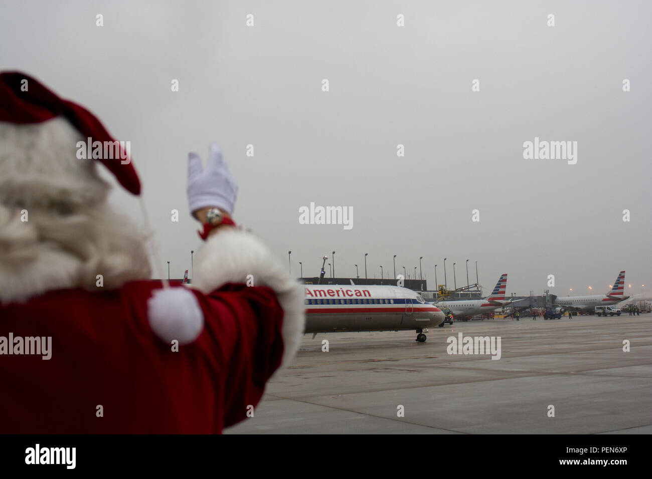Santa Claus waves to the plane while standing on the tarmac as the Snowball Express taxis out to the runway on Dec. 12. The program is sponsored by American Airlines, coordinating flights from 84 cities via nearly 60 chartered and commercial flights. The Snowball Express is a nonprofit organization established in 2006, providing an all-expenses-paid trip to families across the United States with a mission of brining hope and new memories to the children of military heroes who have died while on active duty since Sep. 11, 2001. This year marks the 10th annual celebration, 13 Gold Star families  Stock Photo