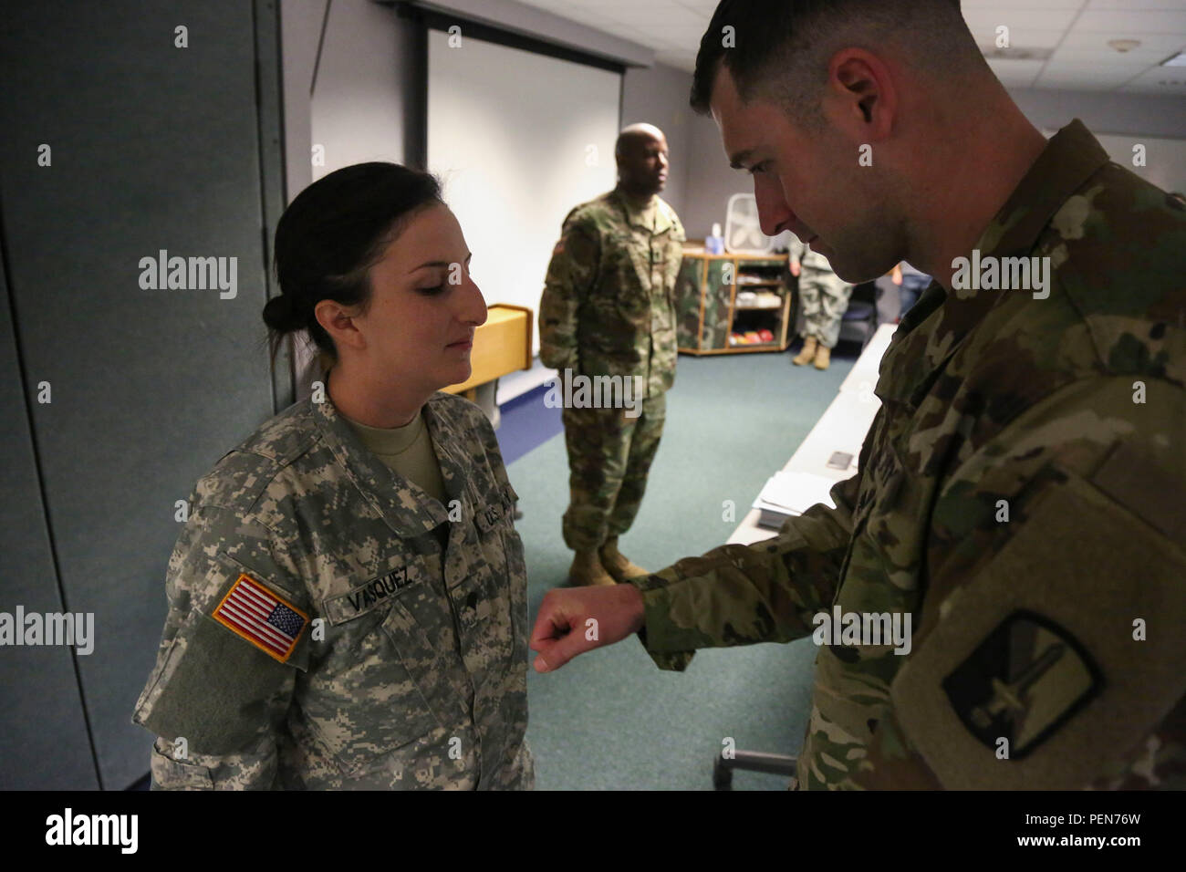 U.S. Army Staff Sgt. Daniel Luksan, right, 55th Signal Company, promotes Pfc. Angelica Vasquez from private first class to specialist, Fort Meade, Md., Nov. 25, 2015. Pfc. Vasquez was promoted to the next rank in view of her hard work, dedication, and potential for leadership. (U.S. Army photo by Pvt. Lewis, Antonio/Released) Stock Photo