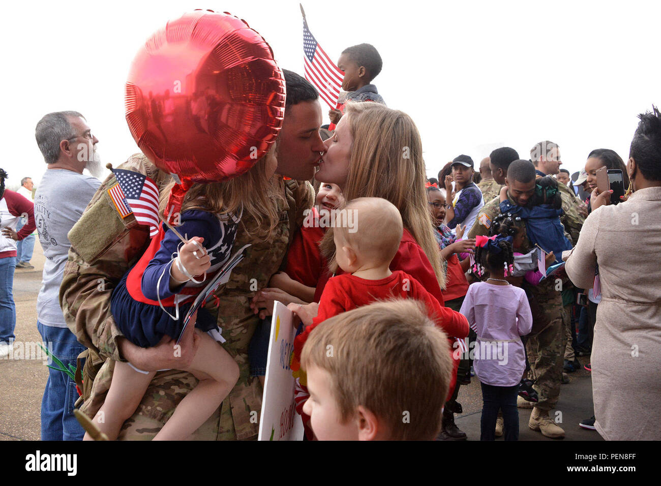 Staff Sgt. Chad Lawless, of Swartz, La., kisses his wife, Angela, and hugs his daughter, Lily, 4, and sons, Luke, 2, and Levi, 6 months. Lawless met Levi for the first time in person at the welcome-home event in Monroe, La., Dec. 24, 2015. More than 150 members of the Louisiana National Guard’s 1023rd Engineer Company, 528th Engineer Battalion just completed a 10-month deployment to Kuwait, with additional missions to Jordan, Iraq and Afghanistan. (U.S. Army National Guard photo by 1st Lt. Rebekah Malone) Stock Photo