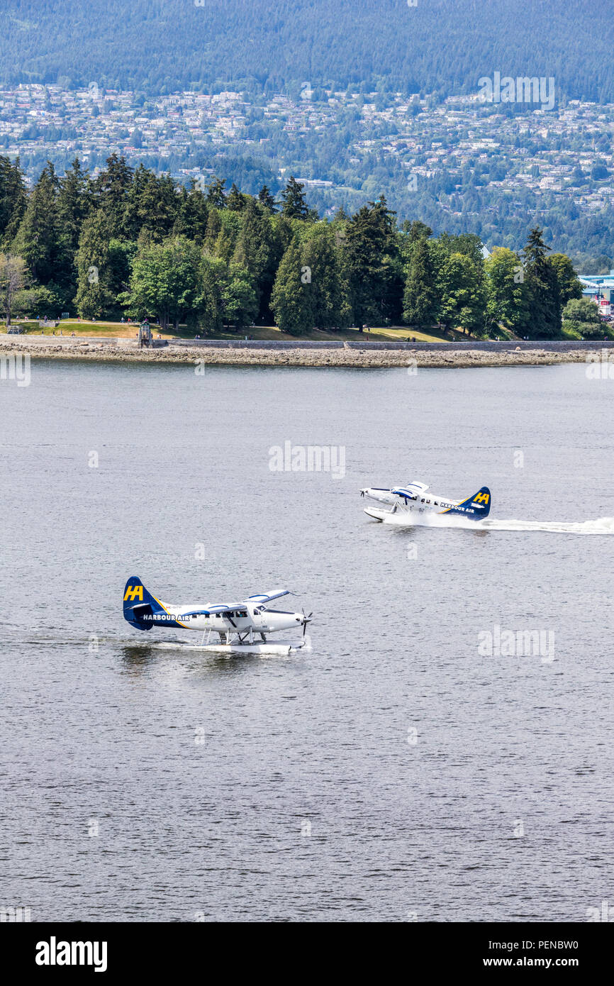 Two tourist seaplanes pass each other in the harbour at Vancouver, British Columbia, Canada Stock Photo