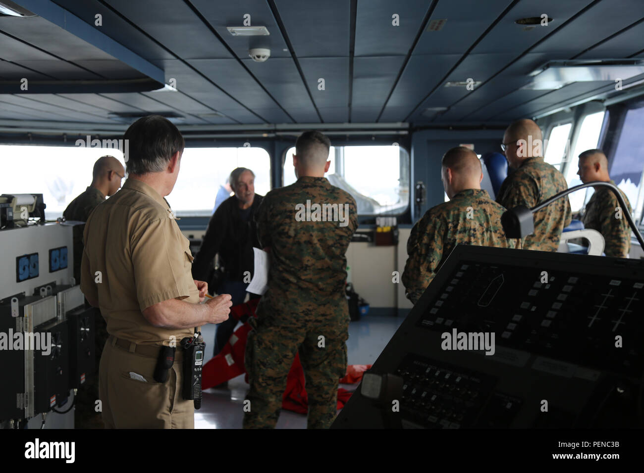151218-M-AY110-005  Dec 18, 2015, USNS Matthew Perry, Philippine Sea, At Sea – The USNS Matthew Perry (T-AKE-9) delivers supplies and goods to various ports and vessels within their area of operation. Marines from 3rd Marine Division surveyed the USNS Matthew Perry in order to plan for future operations aboard the ship, maximizing the ship’s potential for Marines to operate at sea as they did in the past. Marines receive a brief from the ship’s fire marshal on how to use a “Gumby Suit” otherwise known as an immersion survival suit. (U.S. Marine Corps photo by SSgt. Jeffrey S. Caraway/Released) Stock Photo