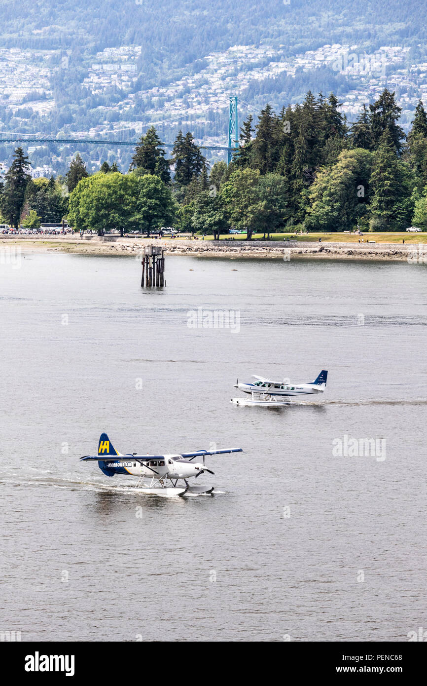 Two tourist seaplanes pass each other in the harbour at Vancouver, British Columbia, Canada Stock Photo