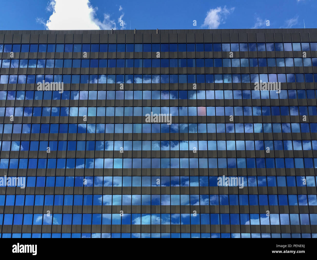 Office building windows with reflecting blue sky and clouds Stock Photo ...