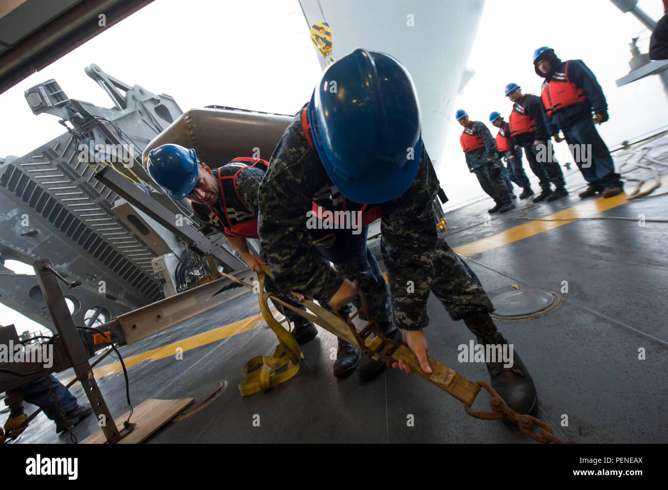 160112-N-QF605-022 ROTA, Spain (Jan. 12, 2016) Boatswain's Mate 2nd Class Ryan Feeney, left and Engineman 3rd Class Sheila Allen tighten a cargo strap to anchor a rigid hull inflatable boat in the mission bay aboard USNS Spearhead (T-EPF 1) Jan. 12, 2015. The Military Sealift Command expeditionary fast transport vessel USNS Spearhead is on a scheduled deployment to the U.S. 6th Fleet area of operations to support the international collaborative capacity-building program Africa Partnership Station. (U.S. Navy photo by Mass Communication Specialist 1st Class Amanda Dunford/Released) Stock Photo
