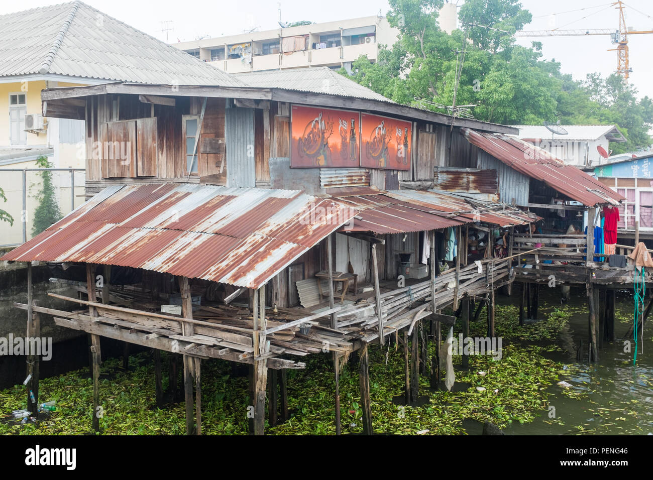 Self built wood and corrugated iron house built on stilts on the Chao Phraya River in Bangkok, Thailand Stock Photo