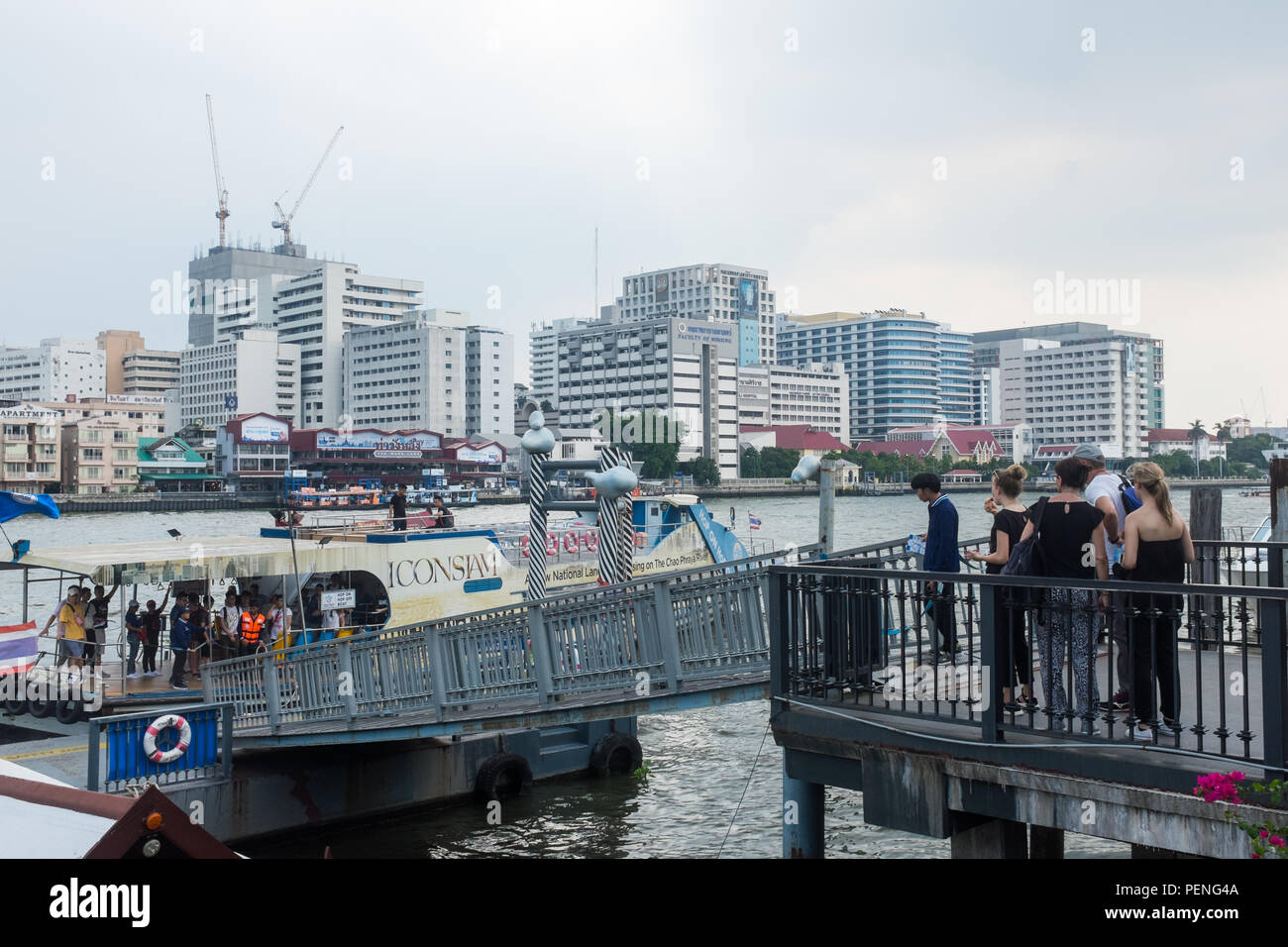 Passengers waiting to board a passenger ferry on the Chao Phraya River in Bangkok, Thailand Stock Photo