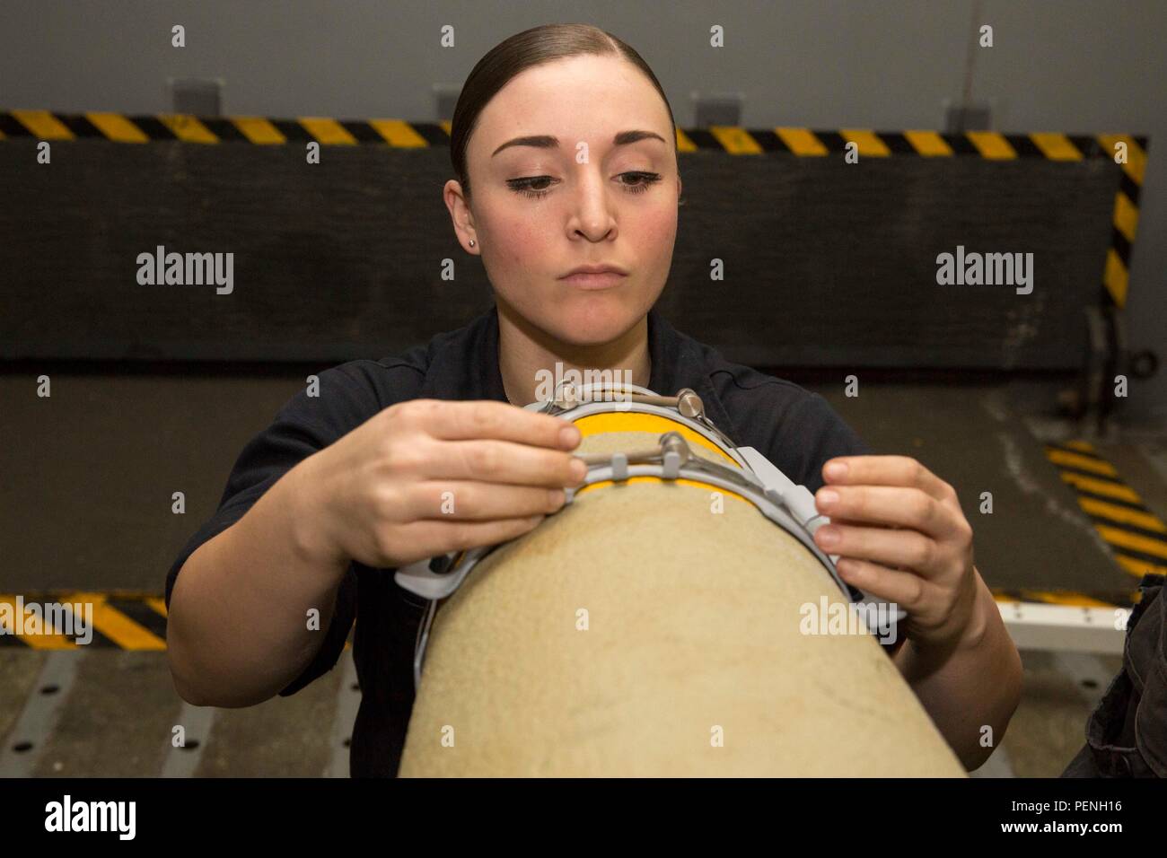 160103-N-KW492-056 ARABIAN GULF (Jan. 3, 2015) Aviation Ordnanceman Airman Tana Eden, from Fort Worth, Texas, installs the strakes of a GBU-32 bomb aboard the amphibious assault ship USS Kearsarge (LHD 3. Kearsarge is the flagship for the Kearsarge Amphibious Ready Group (ARG) and, with the embarked 26th Marine Expeditionary Unit (MEU), is deployed in support of maritime security operations and theater security cooperation efforts in the U.S. 5th Fleet area of operations. (U.S. Navy photo by Mass Communication Specialist Seaman Apprentice Ryre Arciaga/Released) Stock Photo