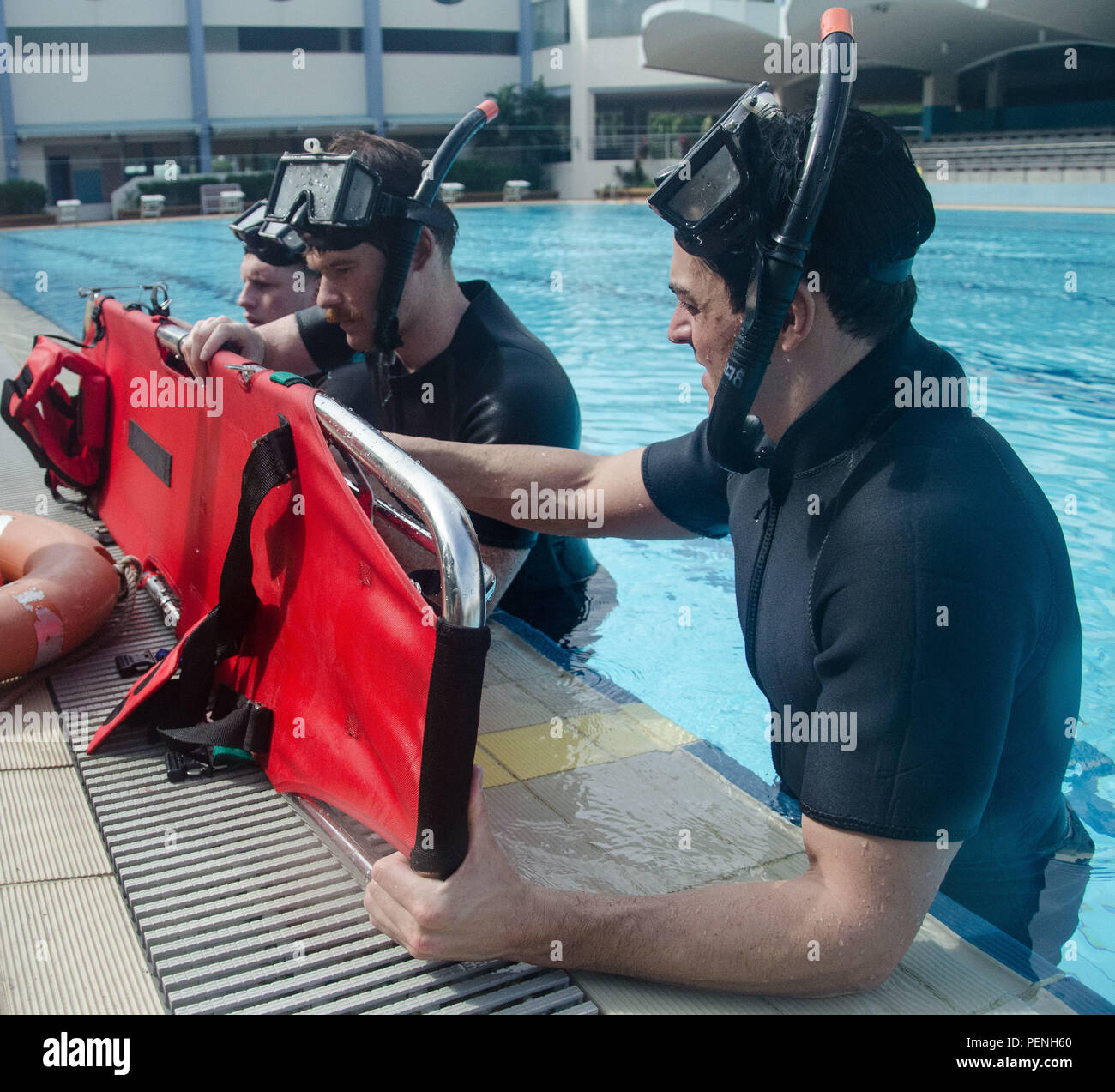 CHANGI NAVAL BASE, Singapore – (Jan. 15, 2016) – Naval Aircrewmen-Tactical  Helicopter 2nd Class Jordan Kowalski, right, Blake Werner, center, and  Daniel Baskin reset a rescue litter for rescue swimmer training. Currently
