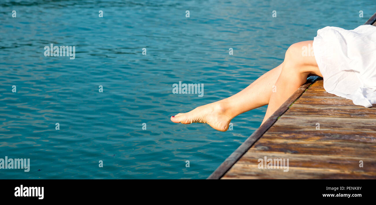 Woman feet on pier. Lake Garda Italy Stock Photo