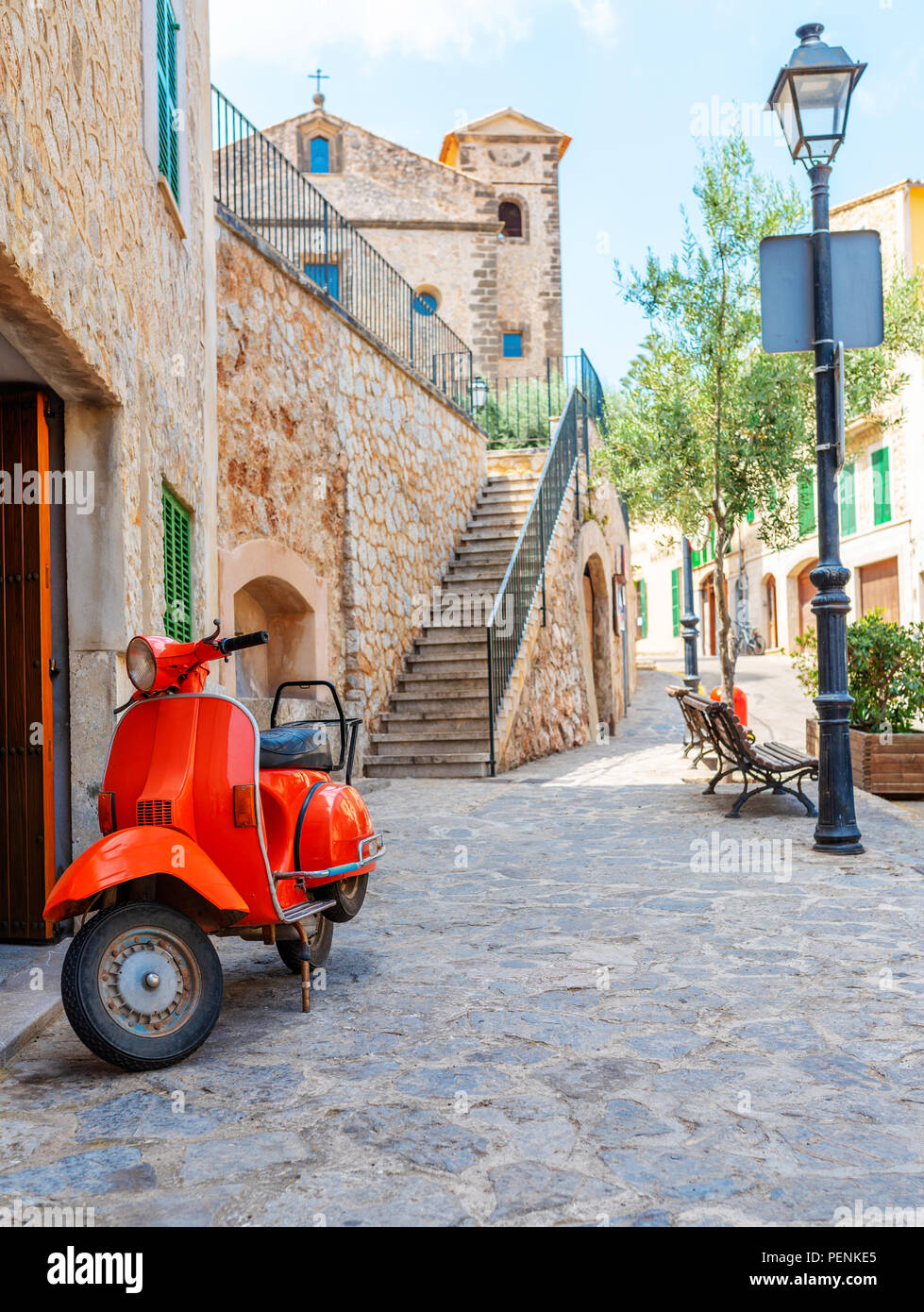 vintage red motor scooter parked in historic spanish village Stock