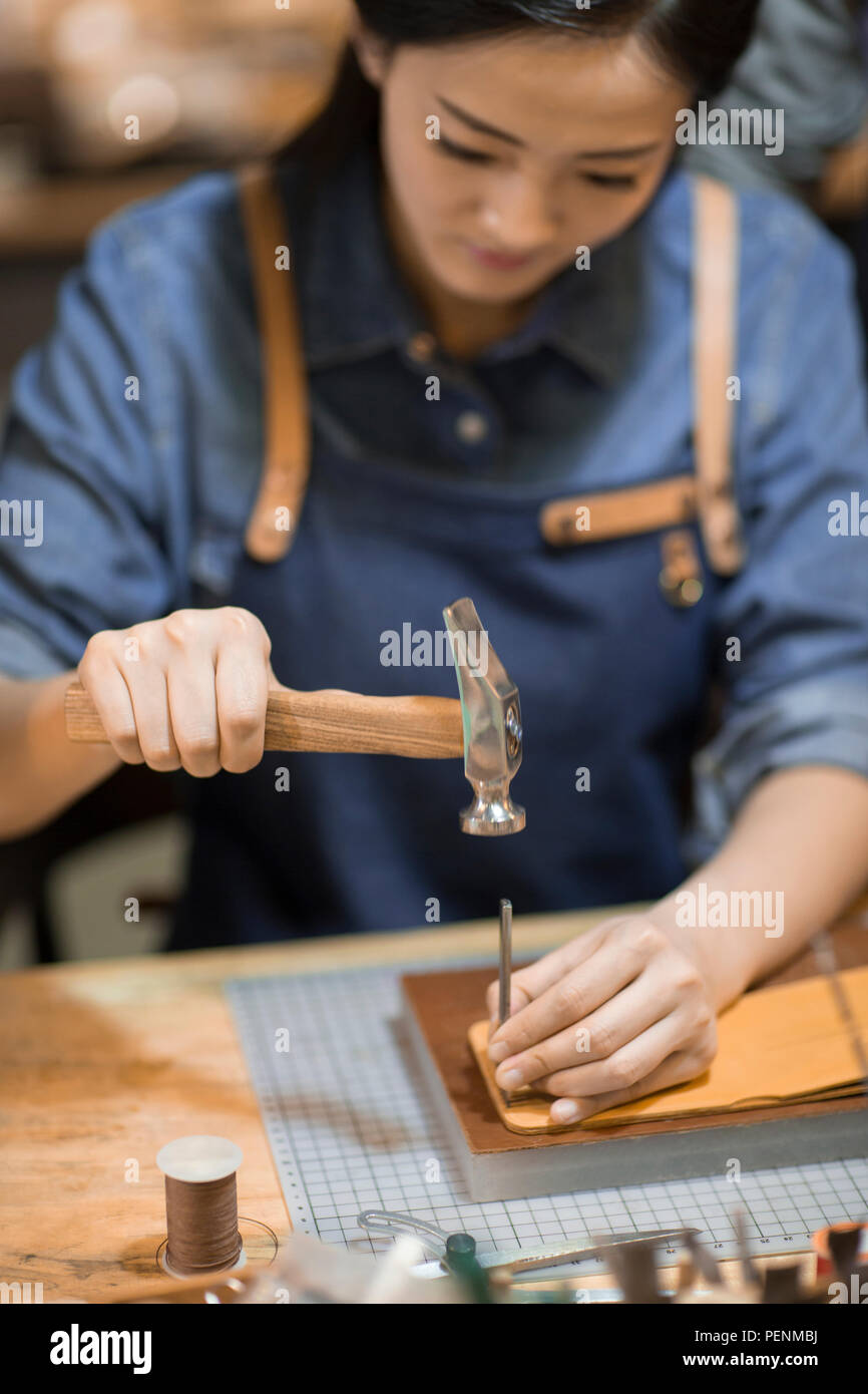Young leather craftswoman working in studio Stock Photo