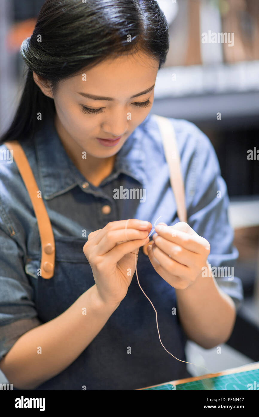 Young leather craftswoman working in studio Stock Photo