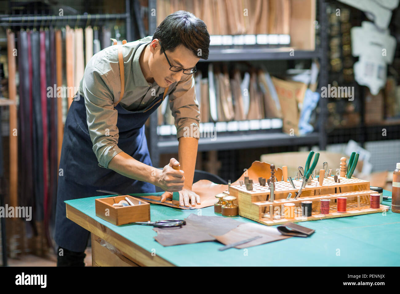 Young leather craftsman working in studio Stock Photo Alamy