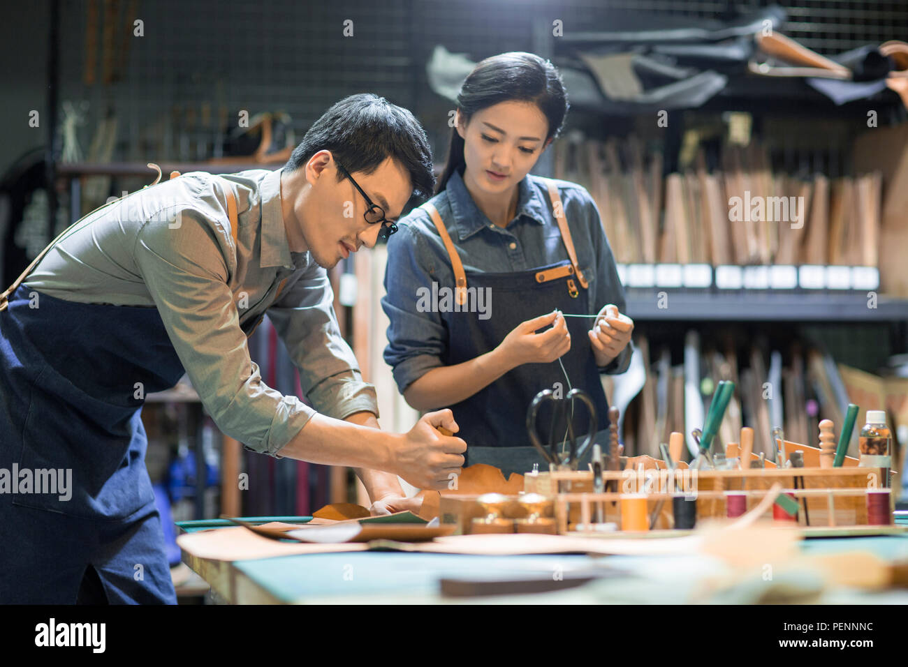 Young leather craftspeople working in studio Stock Photo