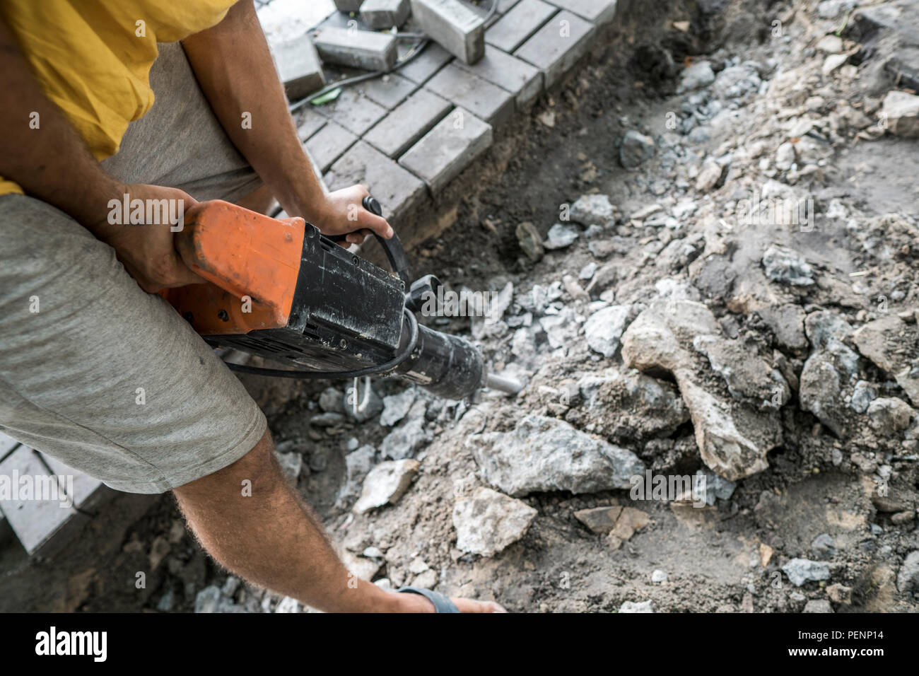 Workers use Electric Concrete Breaker. Male worker repairing driveway surface with jackhammer