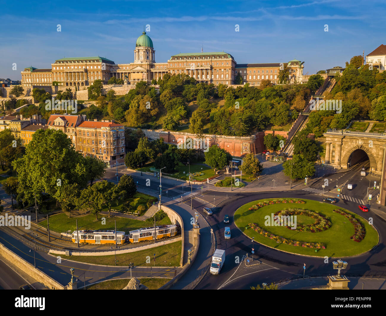 Budapest, Hungary - Clark Adam square roundabout from above at sunrise with Buda Castle Royal Palace and Tunnel and traditional yellow tram Stock Photo