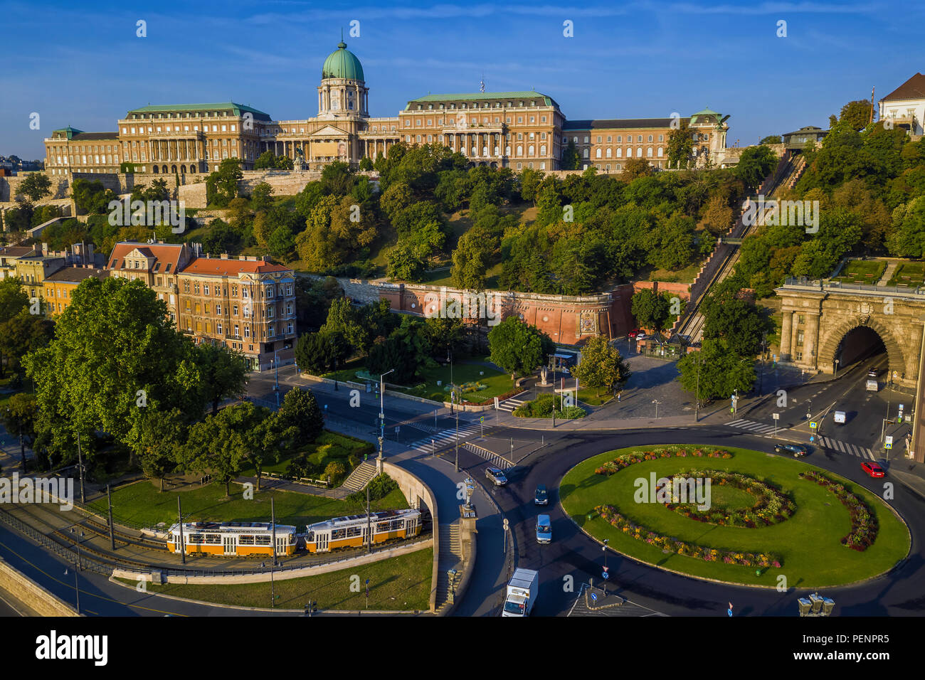 Budapest, Hungary - Clark Adam square roundabout from above at sunrise with Buda Castle Royal Palace and Tunnel and traditional yellow tram Stock Photo