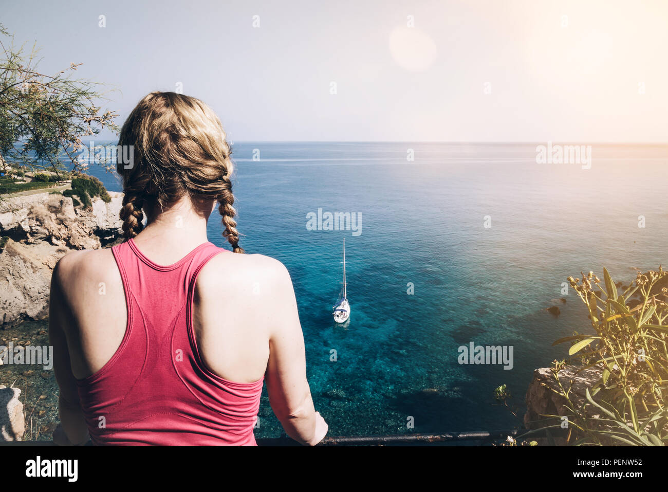 rear view of young woman in sportswear looking at sea Stock Photo