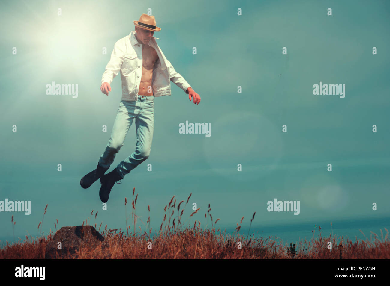 young man flying in fields on cliff Stock Photo