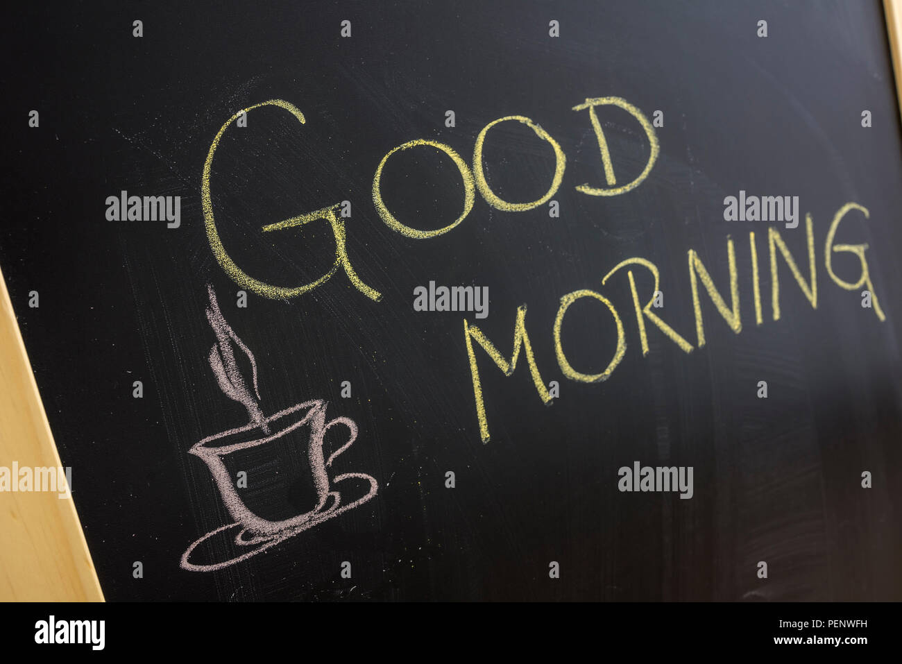 Good morning message with coffee cup written on blackboard. Stock Photo