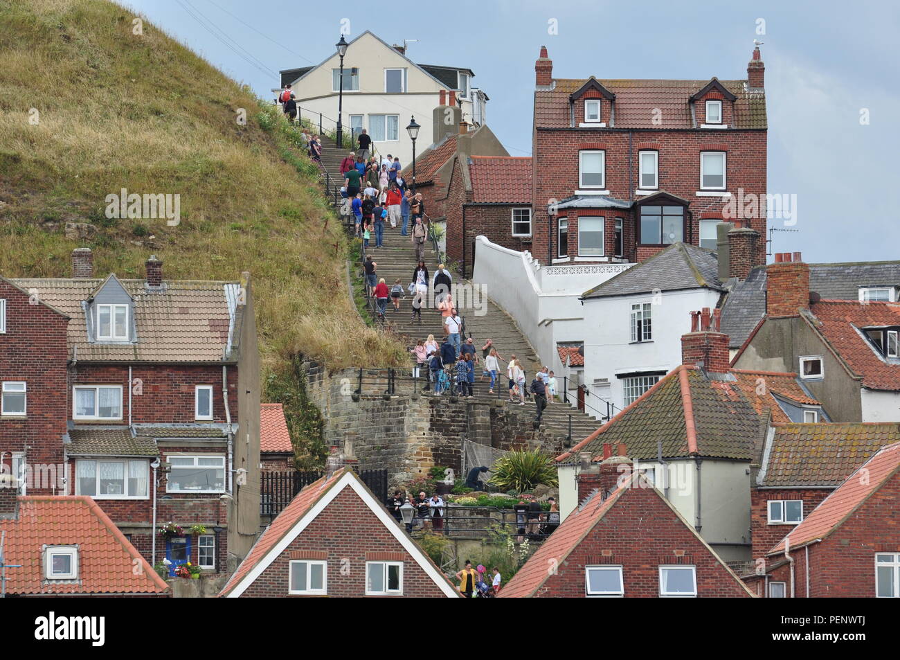 Tourists in Whitby on the steps up to St Mary's church and then Whitby Abbey on the east side of the harbour, north Yorkshire, England, UK. Stock Photo