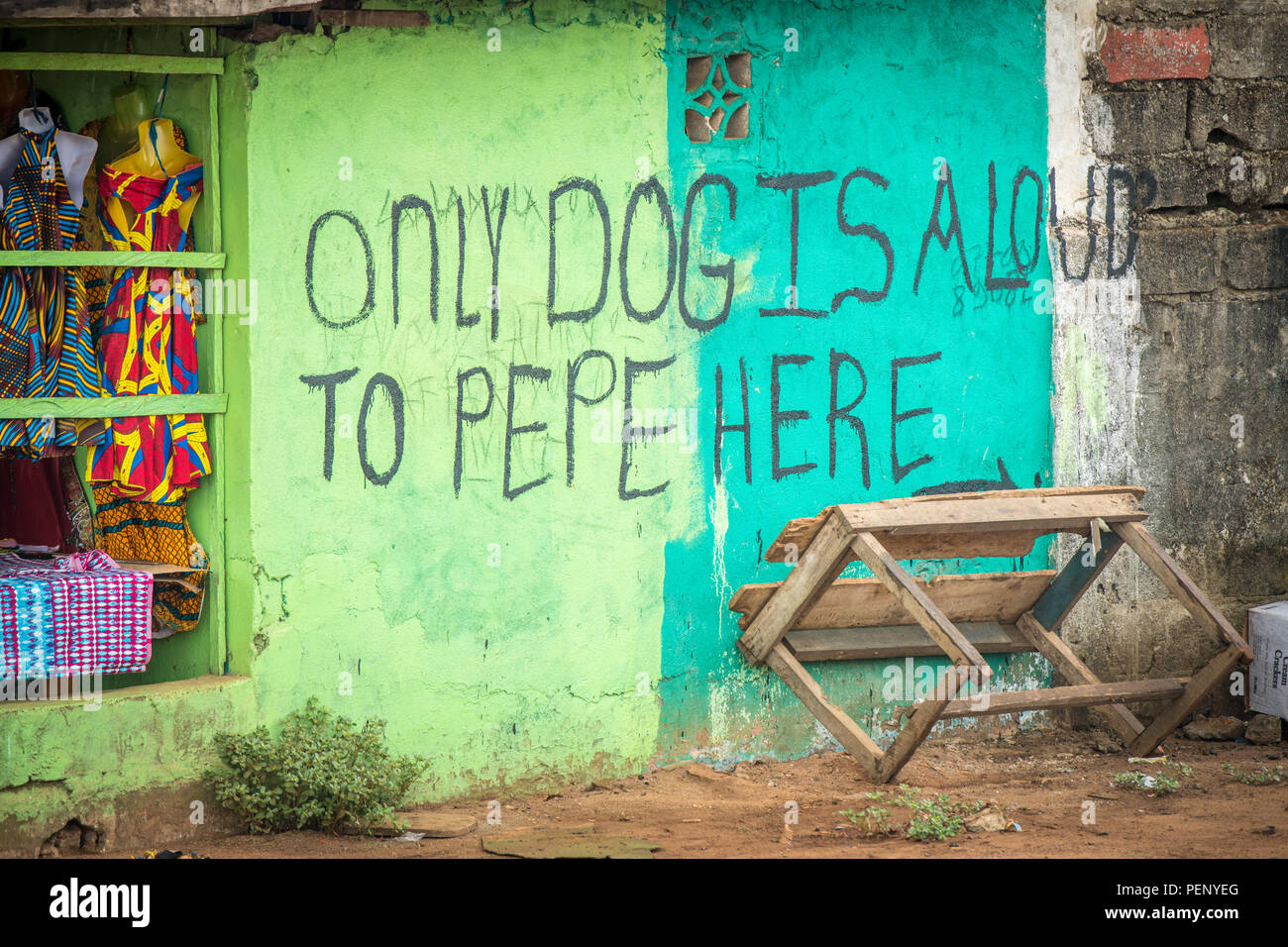 A bright green and blue sign reads 'only dog is aloud to pepe here' Ganta Liberia Stock Photo