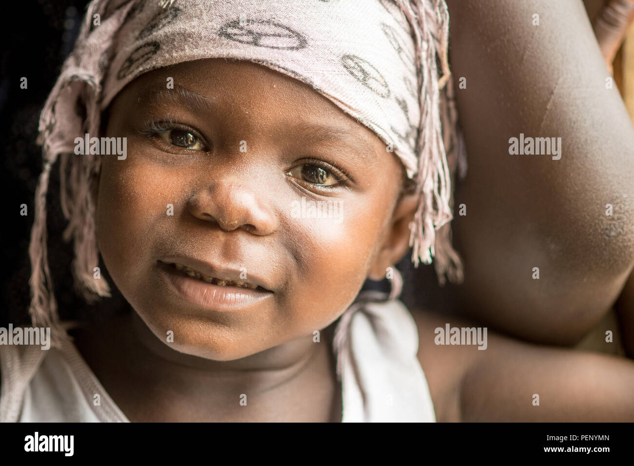 A close up image of a young girl with a wrap on her head in Ganta, Liberia Stock Photo