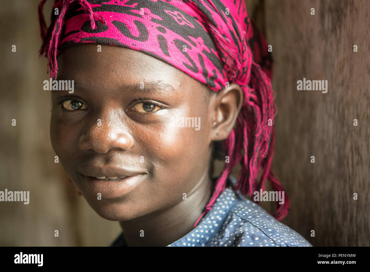 A close up image of a young girl with a wrap on her head in Ganta, Liberia Stock Photo