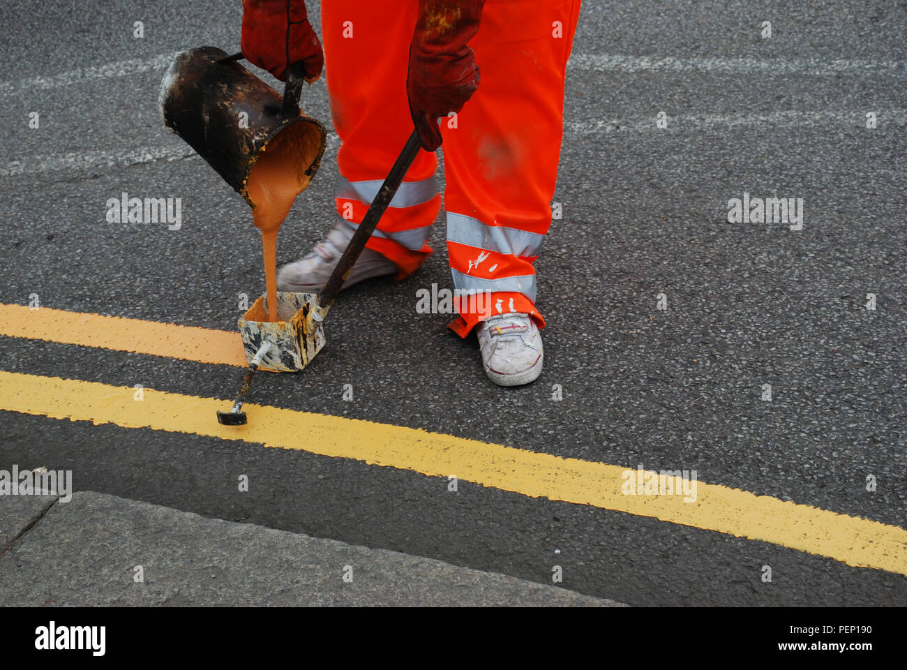 Worker painting double yellow line on the road Stock Photo Alamy