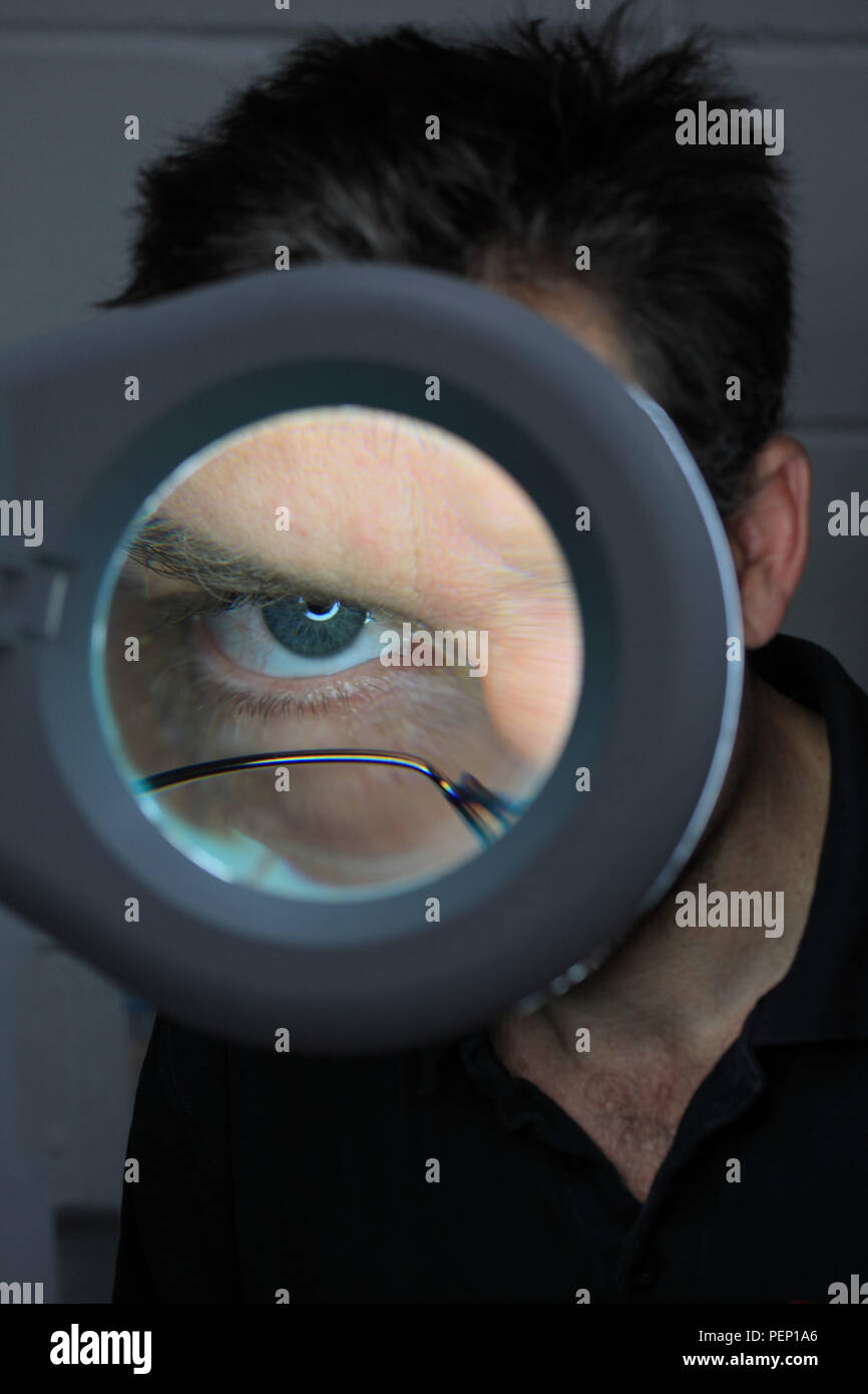 Closeup of eye seen through magnifying loupe Stock Photo Alamy