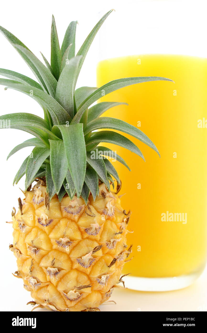 fresh pineapple and a glass of pineapple juice isolated in closeup view ...