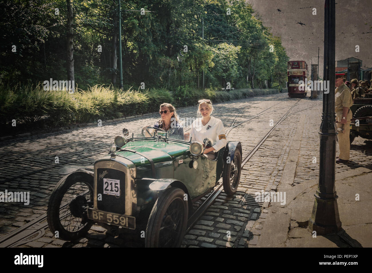 Crich Tramway Village, Derbys, 1940s event. Vintage street scene & the girls are out cruising to impress & enjoying their vintage Austin motor car! Stock Photo