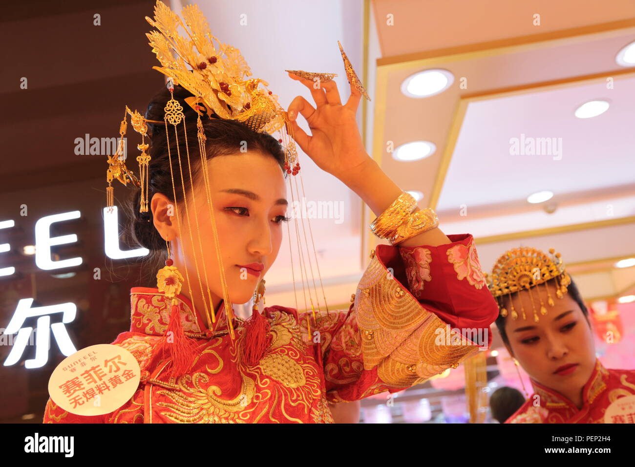 Pingliang, Pingliang, China. 16th Aug, 2018. Pingliang, CHINA-Models present gold wedding dresses and accessories at a shopping mall in Pingliang, northwest China's Gansu Province. The wedding dresses and accessories are made of 9.99 kg gold, which cost more than five million yuan (US$ 724,973) Credit: SIPA Asia/ZUMA Wire/Alamy Live News Stock Photo