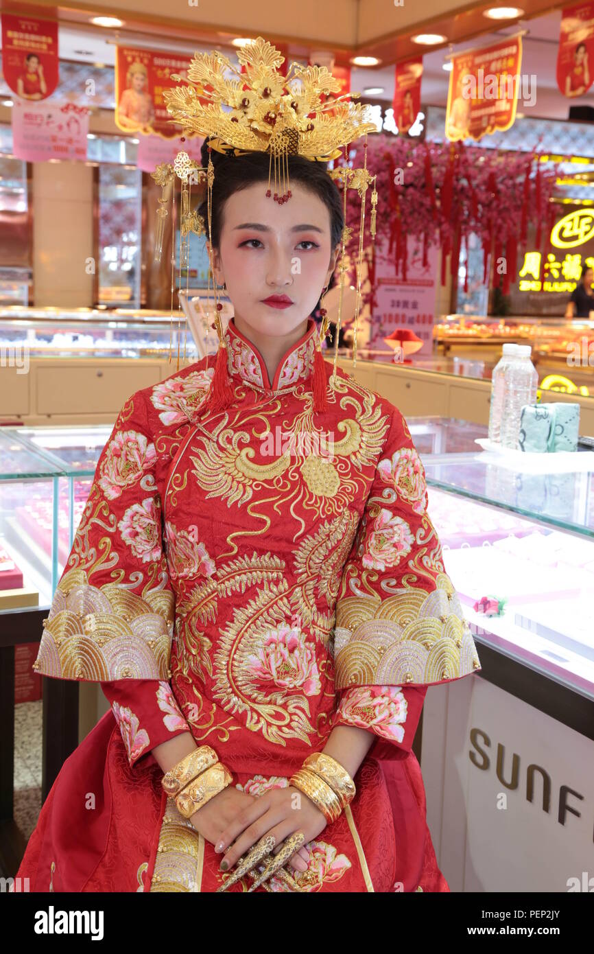 Pingliang, China. 16th Aug, 2018. Pingliang, CHINA-Models present gold  wedding dresses and accessories at a shopping mall in Pingliang, northwest  China's Gansu Province. The wedding dresses and accessories are made of 9.99