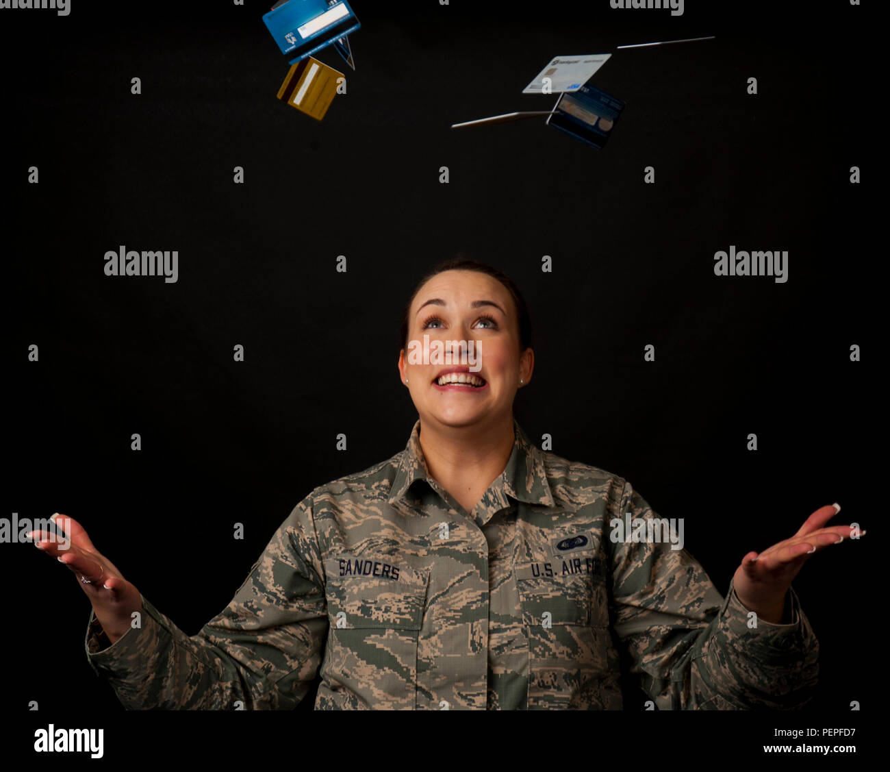 In this photo illustration, Staff Sgt. Kya Sanders, 90th Security Support Squadron administration, tosses away credit cards, symbolizing the credit card debt she and her fellow Financial Peace University graduates eliminated and the credit card offers they turned down during the 12-week course. The FPU course hosted by the 90th Missile Wing chapel follows financial author and spokesman Dave Ramsey's 'Financial Peace Military' curriculum, which is similar to the standard FPU course, but with an emphasis on military-specific financial topics. (U.S. Air Force photo illustration by Senior Airman J Stock Photo