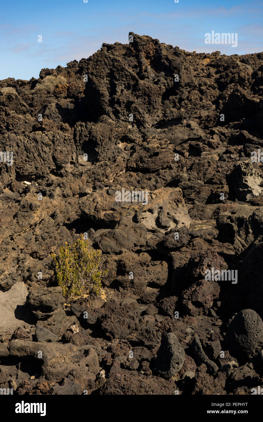 Black volcanic rock formation with blue sky on Lanzarote Island Stock Photo