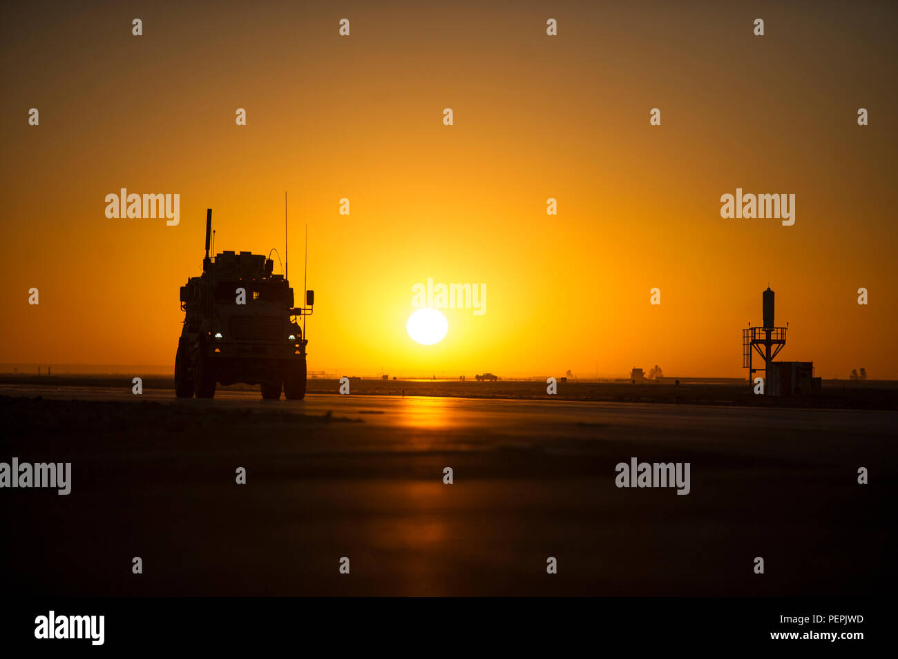 A Mine Resistant Ambush Protected vehicle, driven by a member of the 451st Expeditionary Support Squadron Security Forces Flight, patrols the flightline as the sun sets on Kandahar Airfield, Afghanistan, Jan. 20, 2016. Security Forces members at KAF are responsible for the security of more than 150 aircraft and $2.2 billion of resources. (U.S. Air Force photo/Tech. Sgt. Robert Cloys) Stock Photo