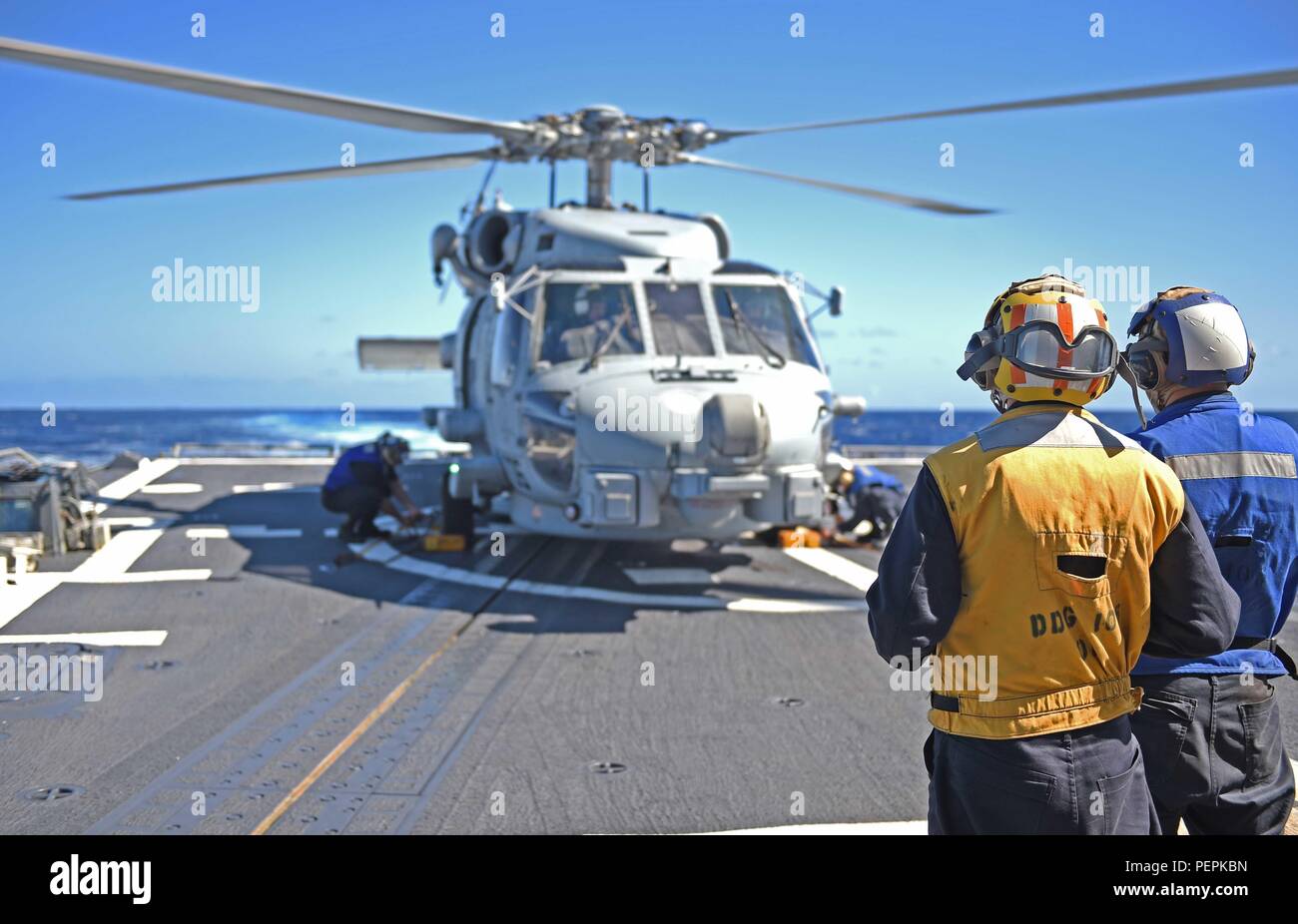 160123-N-KM939-198 PACIFIC OCEAN (Jan 23, 2016) - Sailors monitor the removal of chocks and chains from an MH-60R Sea Hawk helicopter during flight operations on the guided-missile destroyer, USS Stockdale (DDG-106). Providing a combat-ready force to protect collective maritime interests, Stockdale, assigned to the Stennis strike group, is operating as part of the Great Green Fleet on a regularly scheduled Western Pacific deployment. (U.S. Navy photo by Mass Communication Specialist 3rd Class David A. Cox/Released) Stock Photo