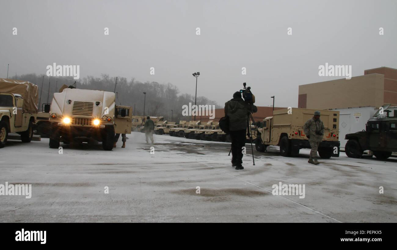 A reporter braves the cold to capture D.C. National Guard Soldiers and Airmen Tactical vehicles as they prepare to roll out into the District to support Metropolitan Police Department (MPD), Fire and Emergency Service Medical Department (FEMS) during Winter Storm Jonas, Joint Base Anacostia-Bolling, D.C., Jan. 22. District of Columbia National Guard Soldiers and Airmen answer the call to provide transportation support during freezing temperatures and heavy snowfall Jan. 22-25. Stock Photo