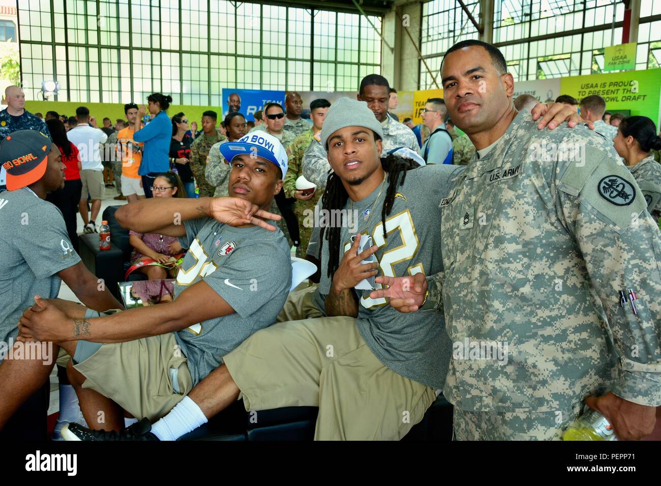 Kansas City Chief Cornerback Marcus Peters and San Diego Chargers Cornerback Jason Verrett stop for a quick photo opportunity with Sgt. 1st Class Kevin Edmondson, Regional Health Command-Pacific, while watching the 2016 Pro Bowl Draft show at Wheeler Army Airfield, Hawaii, Jan. 27. Stock Photo
