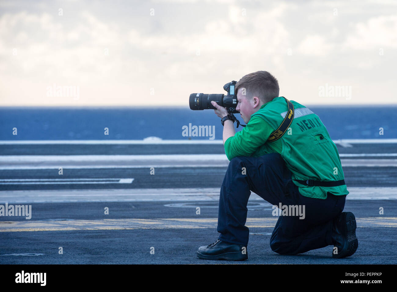 160128-N-XX566-143 PACIFIC OCEAN  (Jan. 28, 2016) - Mass Communication Specialist Seaman Cole Pielop, from Rathdrum, Idaho, takes photographs on USS John C. Stennis' (CVN 74) flight deck. Providing a combat-ready force to protect collective maritime interests, Stennis is operating as part of the Great Green Fleet on a regularly scheduled Western Pacific deployment. (U.S. Navy photo by Mass Communication Specialist 3rd Class Andre T. Richard/ Released) Stock Photo