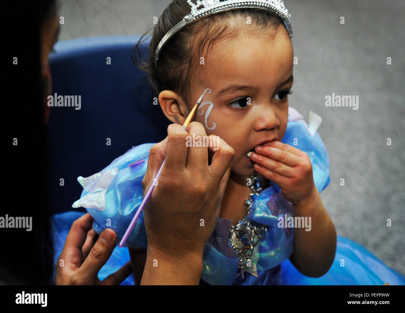 A volunteer paints a child’s face during a Kinder Fasching celebration Jan. 25, 2016, at Ramstein Air Base, Germany. Fasching is Germany’s carnival season and is a time of festivity. The main fasching parades take place on Carnival Sunday and Rose Monday, Feb. 7 and 8. (U.S. Air Force photo/Airman 1st Class Larissa Greatwood) Stock Photo