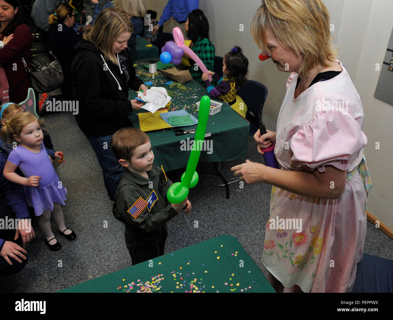 Tina Kamber, a balloon artist, makes a balloon sword for a child during a Kinder Fasching celebration Jan. 25, 2016, at Ramstein Air Base, Germany. The event had games, a bounce house, a balloon artist, face painting, popcorn and dance performances. (U.S. Air Force photo/Airman 1st Class Larissa Greatwood) Stock Photo