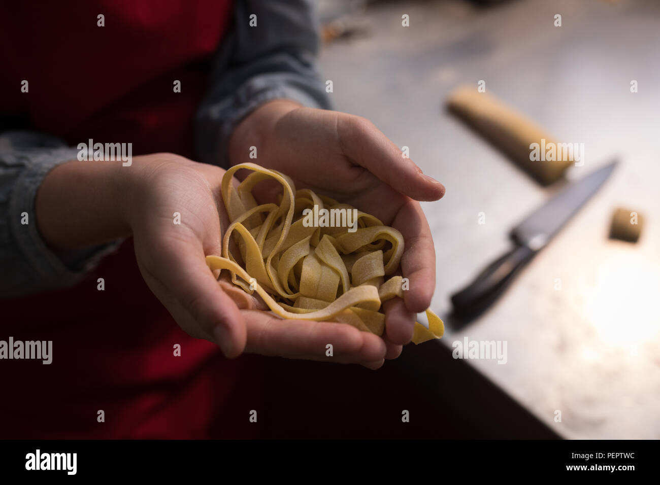 Tagliatelle in hand while baker making tagliatelle Stock Photo
